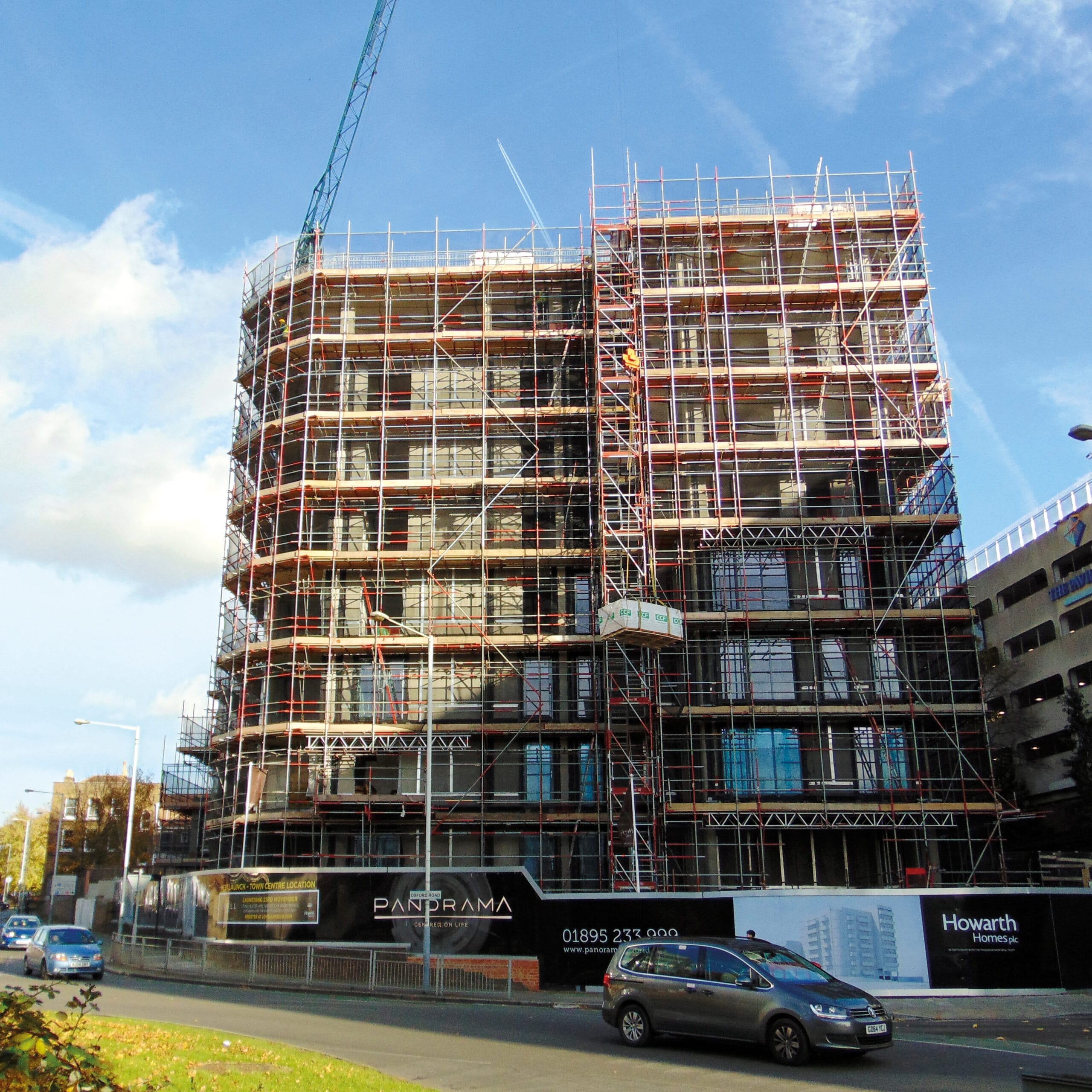 Multi-storey building under construction with scaffolding and crane