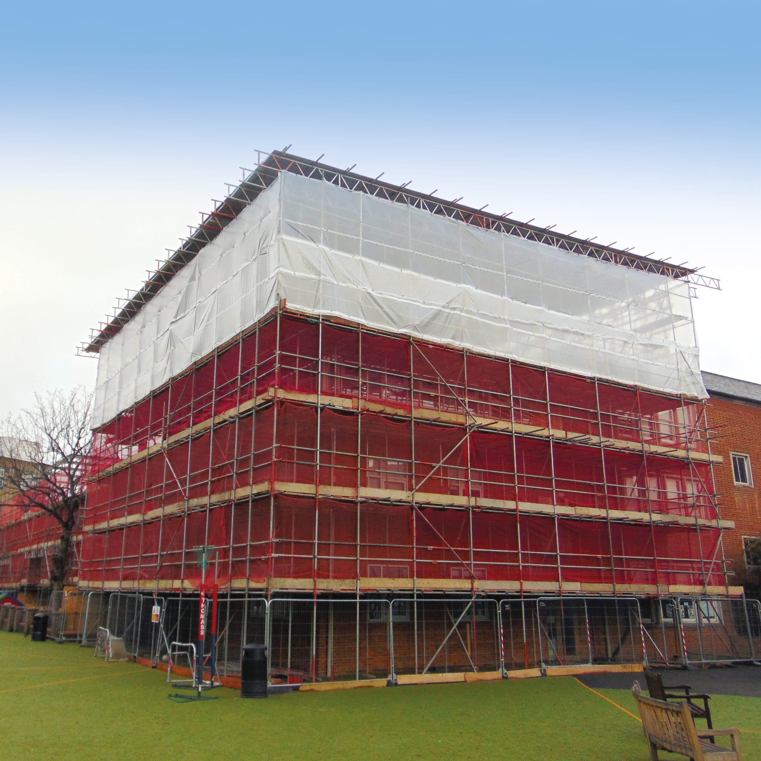 Building wrapped in scaffolding and protective sheeting