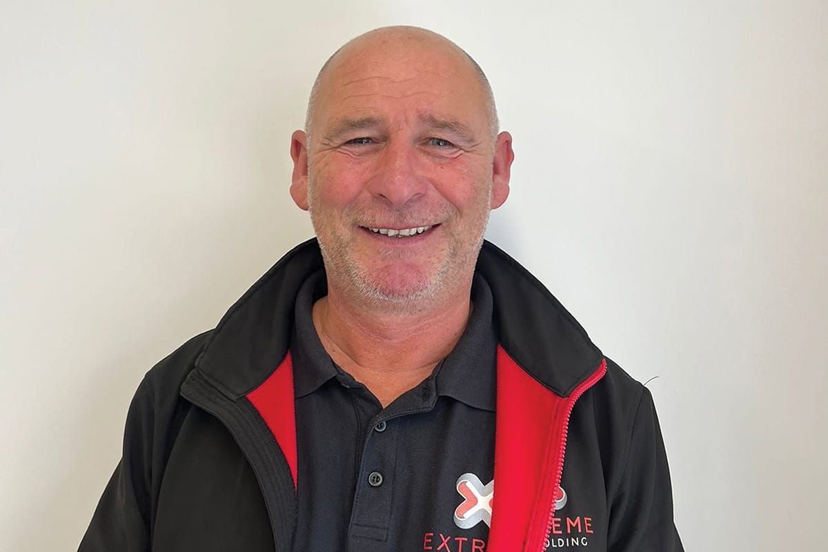Smiling man in branded work jacket indoors