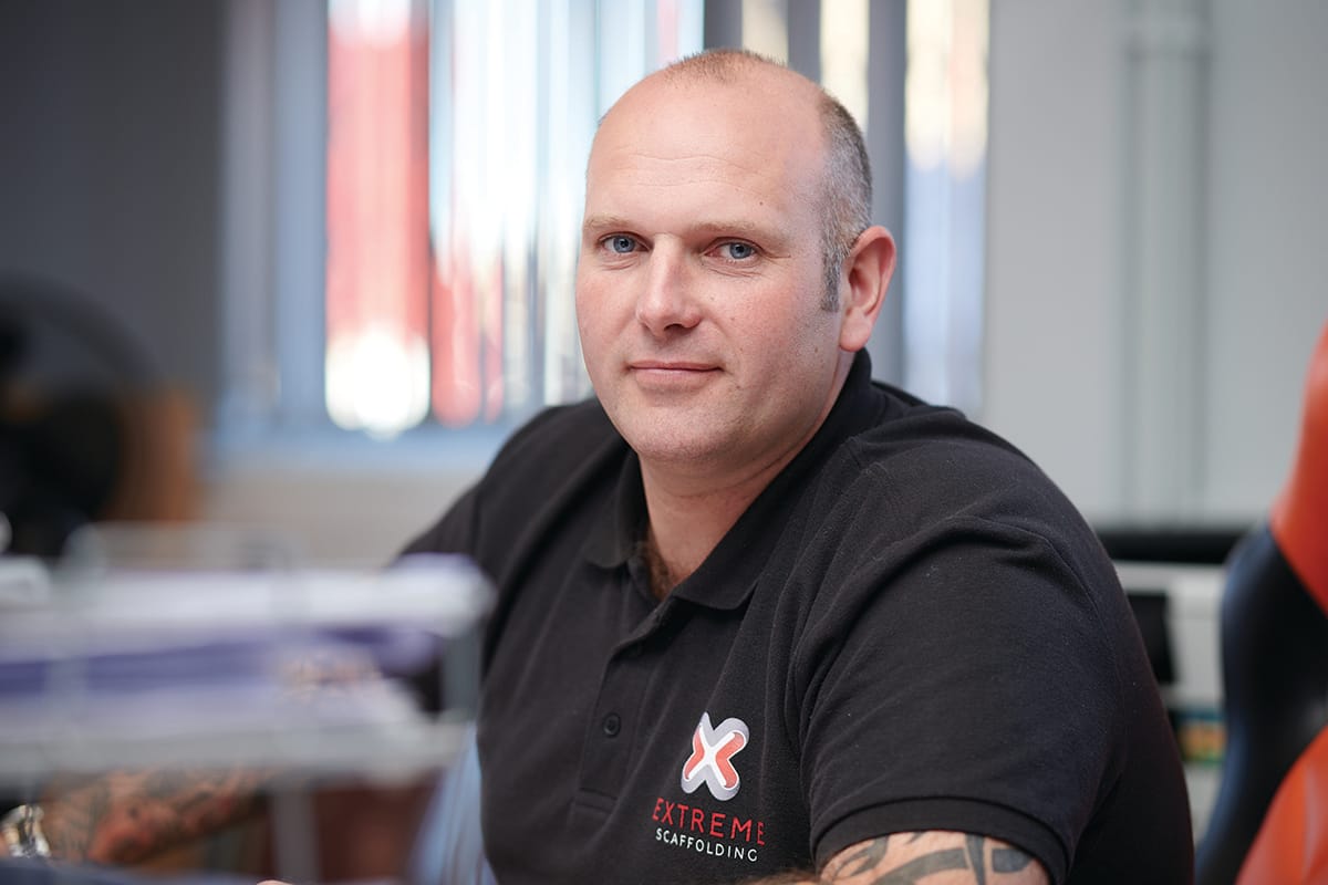 Man in Extreme Scaffolding polo shirt indoors