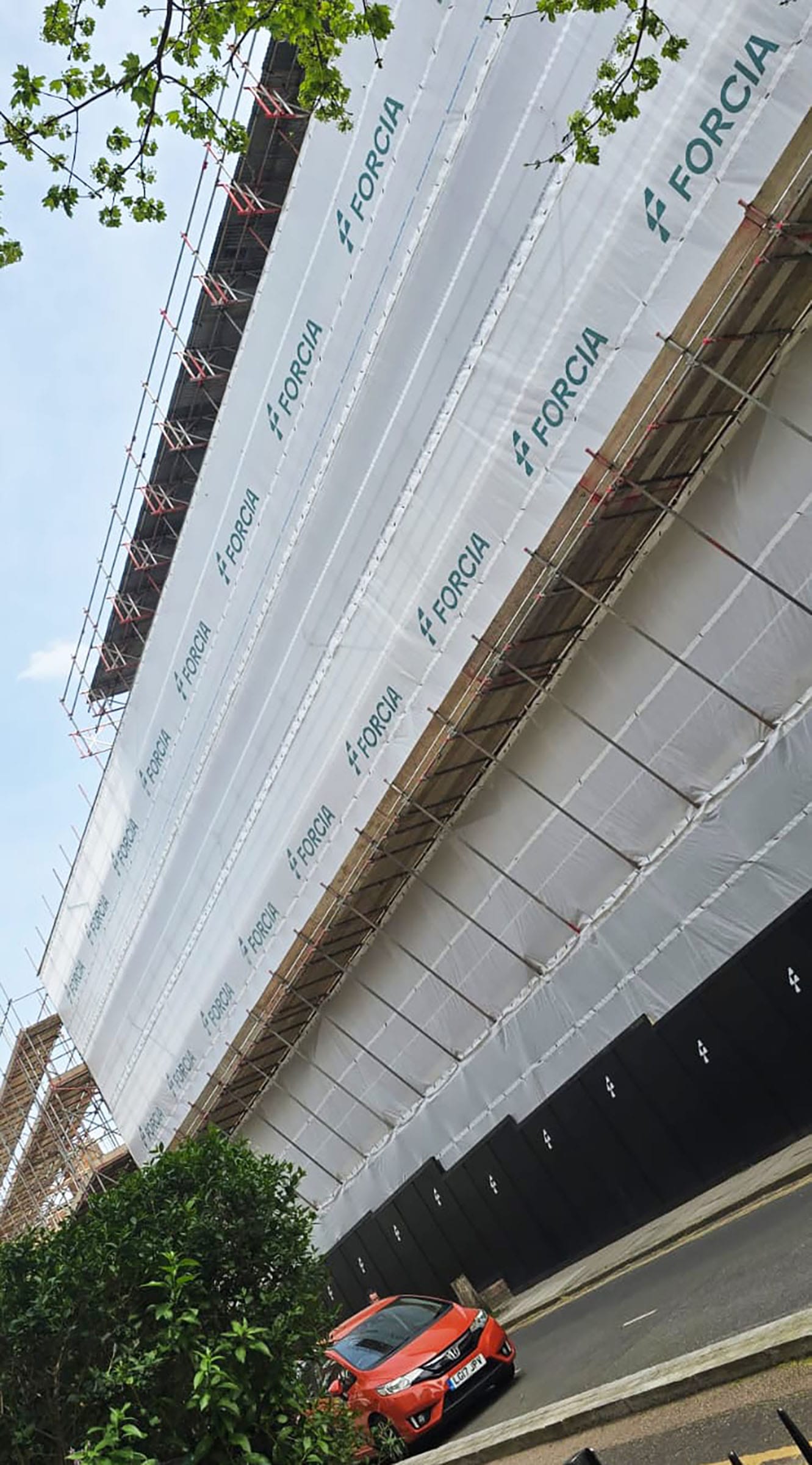 Building under scaffolding with white Forcia sheeting