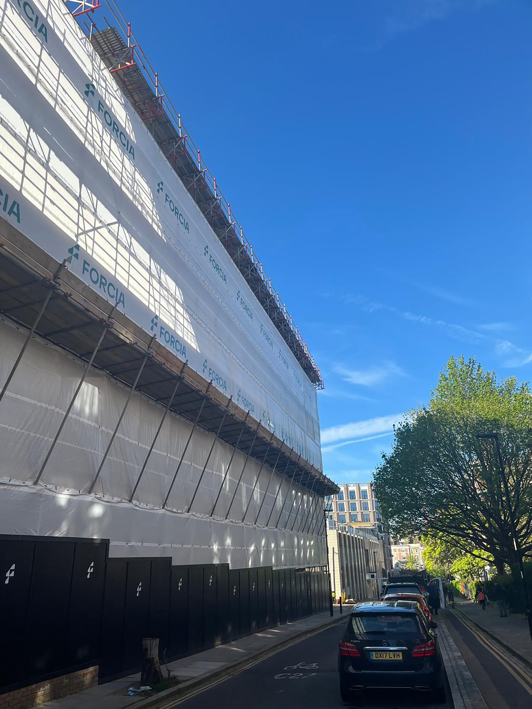 Building under scaffolding on sunny city street